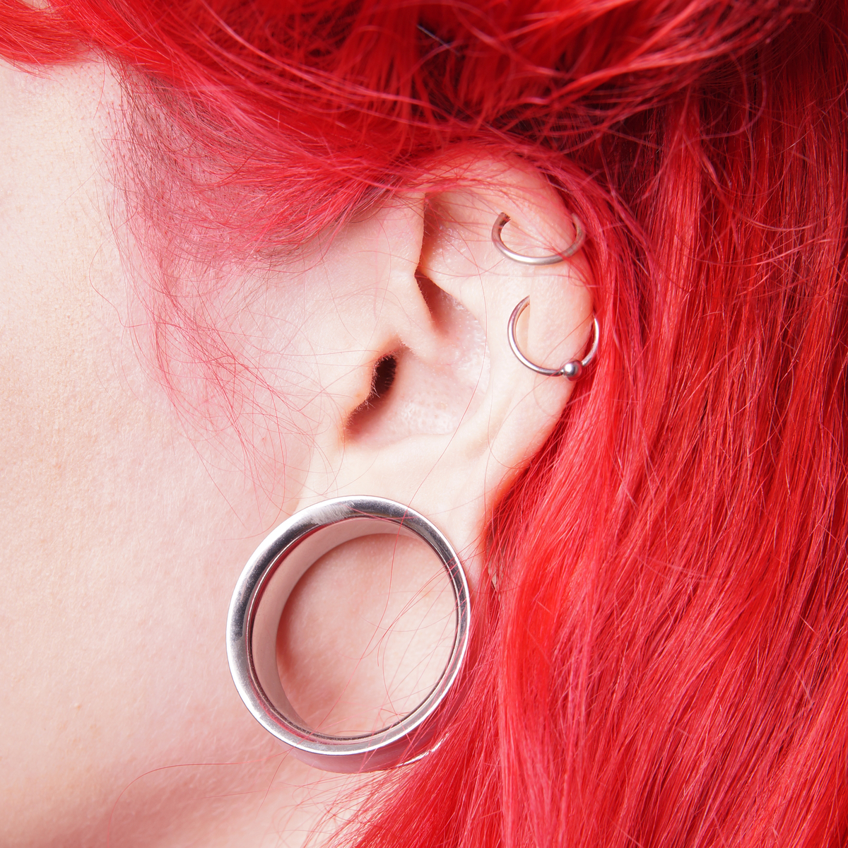 Patient with earlobe gauge and cartilage piercings